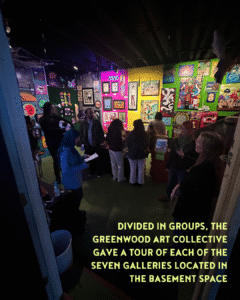 A group of people stands in an art gallery space with colorful artwork on the walls; text explains tours of the seven basement galleries by the Greenwood Art Collective.
